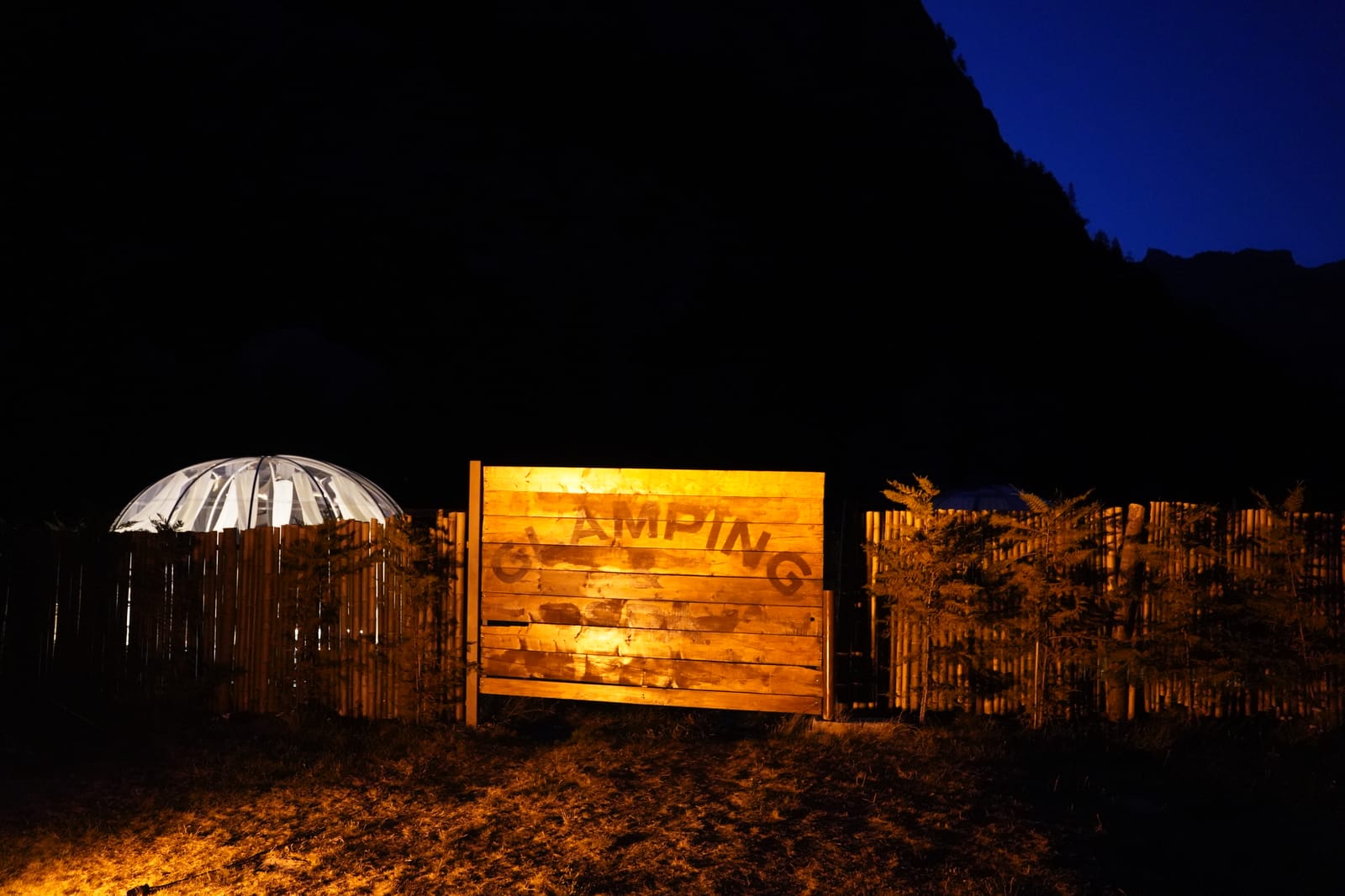 Insegna del glamping illuminata di notte
