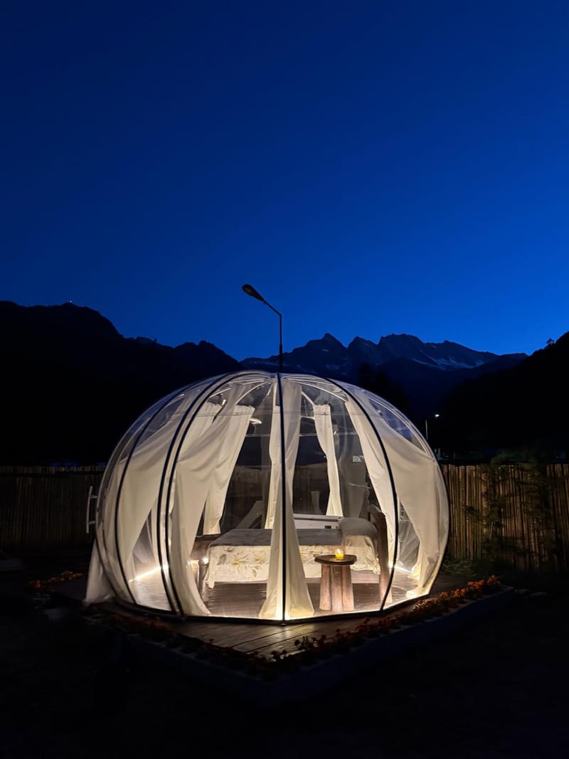 Cupola glamping all'ora blu con vetta alpina sullo sfondo