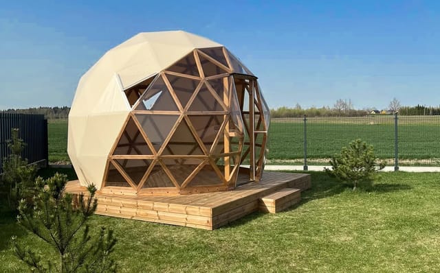 Cupola con struttura in legno e pedana, montata su un prato