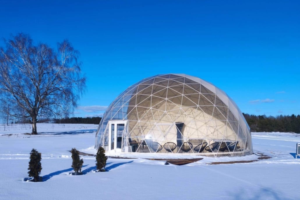 Cupola geodetica sulla neve sotto un cielo terso d'inverno