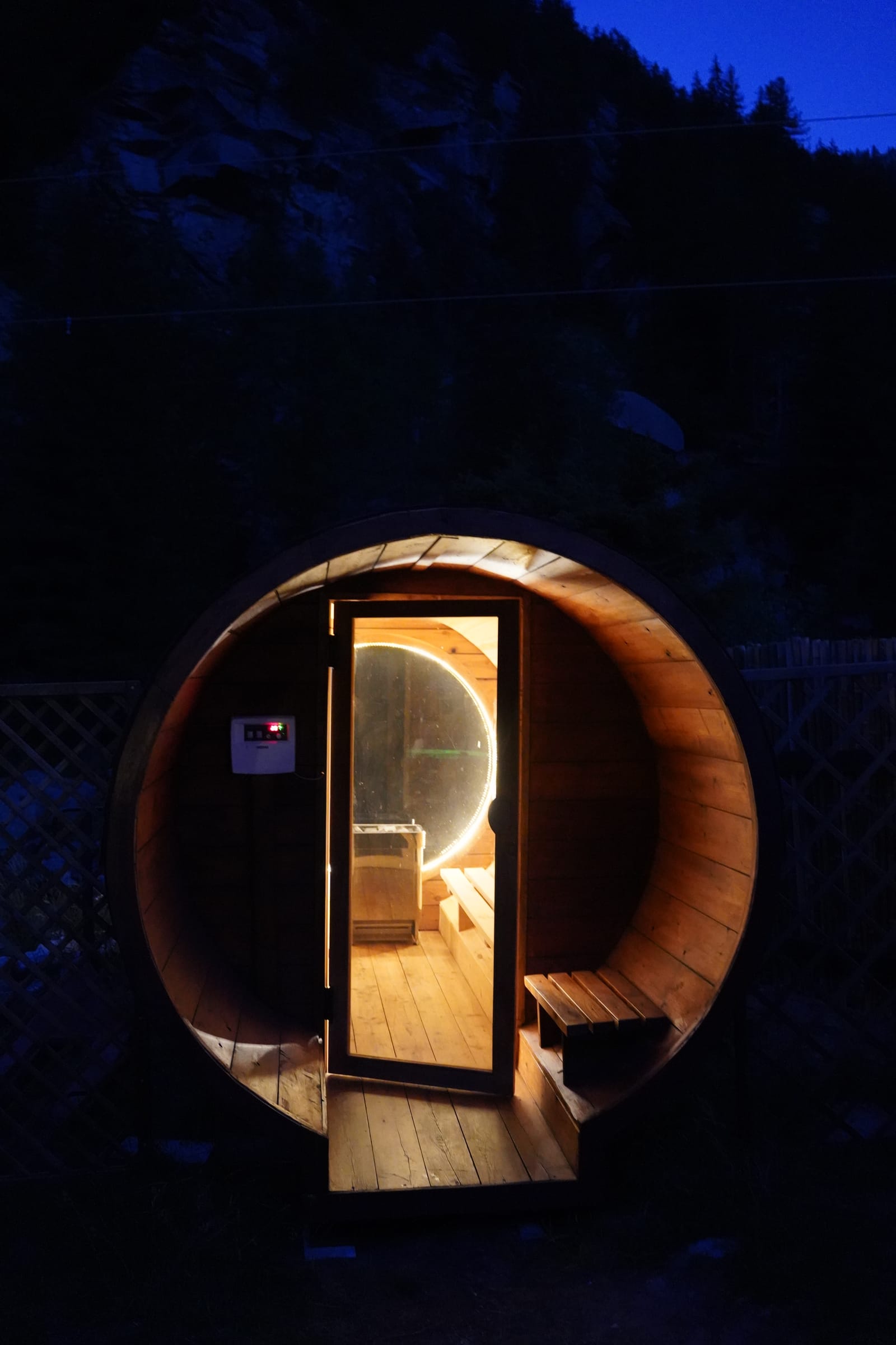 Ingresso della sauna a botte in legno con oblò illuminato