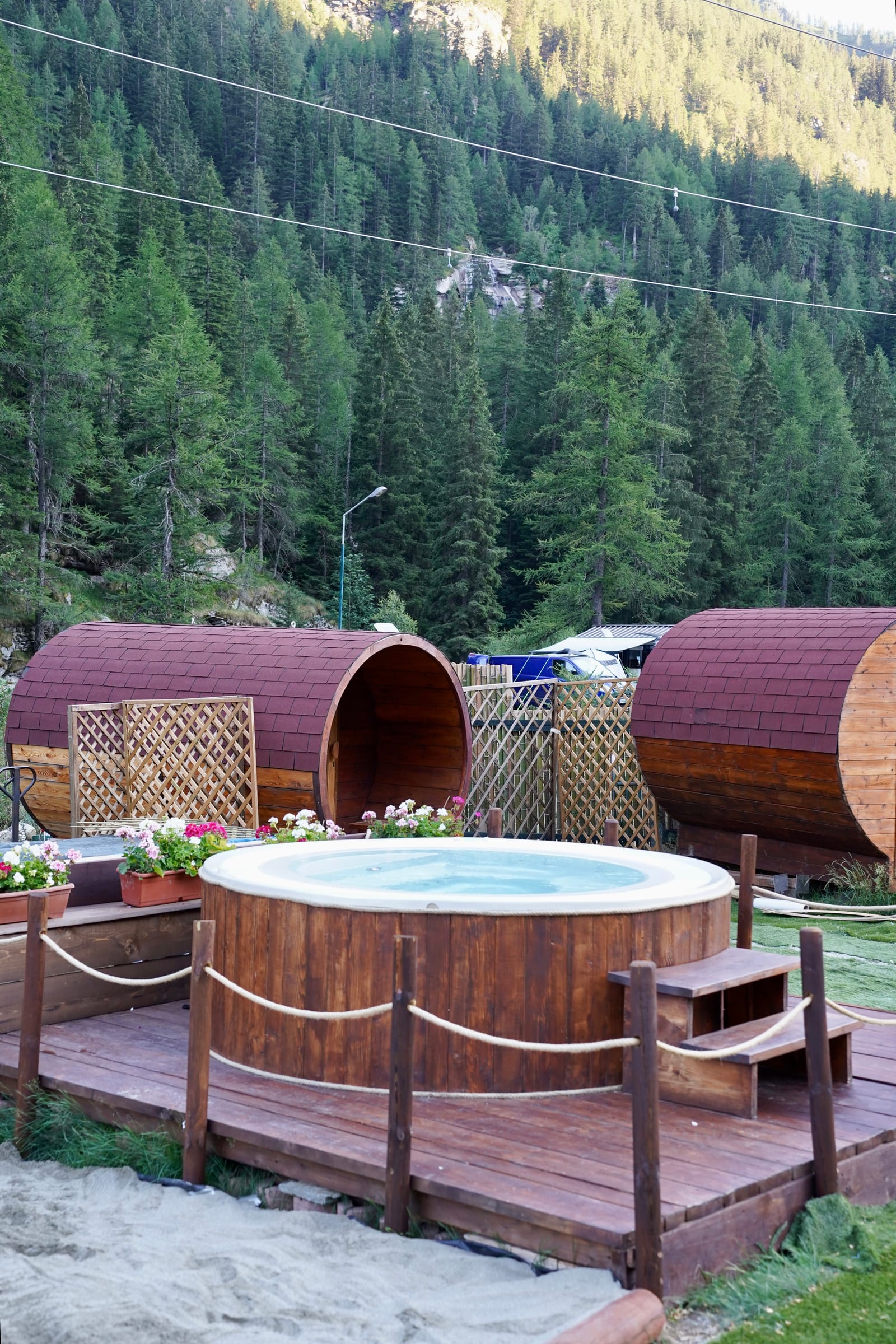 Sauna a botte e vasca esterna installate su una pedana in legno