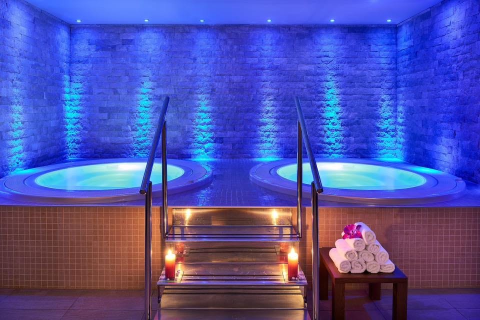 Due vasche idromassaggio rotonde in una spa illuminata di blu